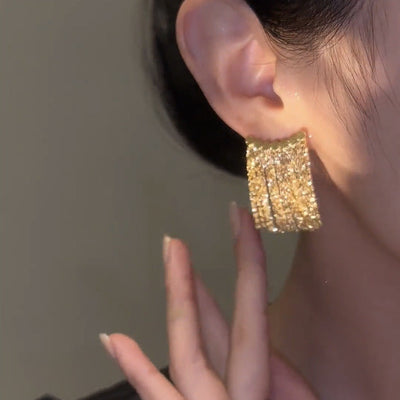 Lange Ohrringe mit geschwungenem Stab und Quaste