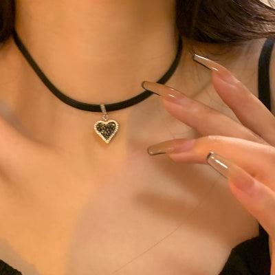 Schwarze Herz-Ohrringe mit funkelnden Diamanten