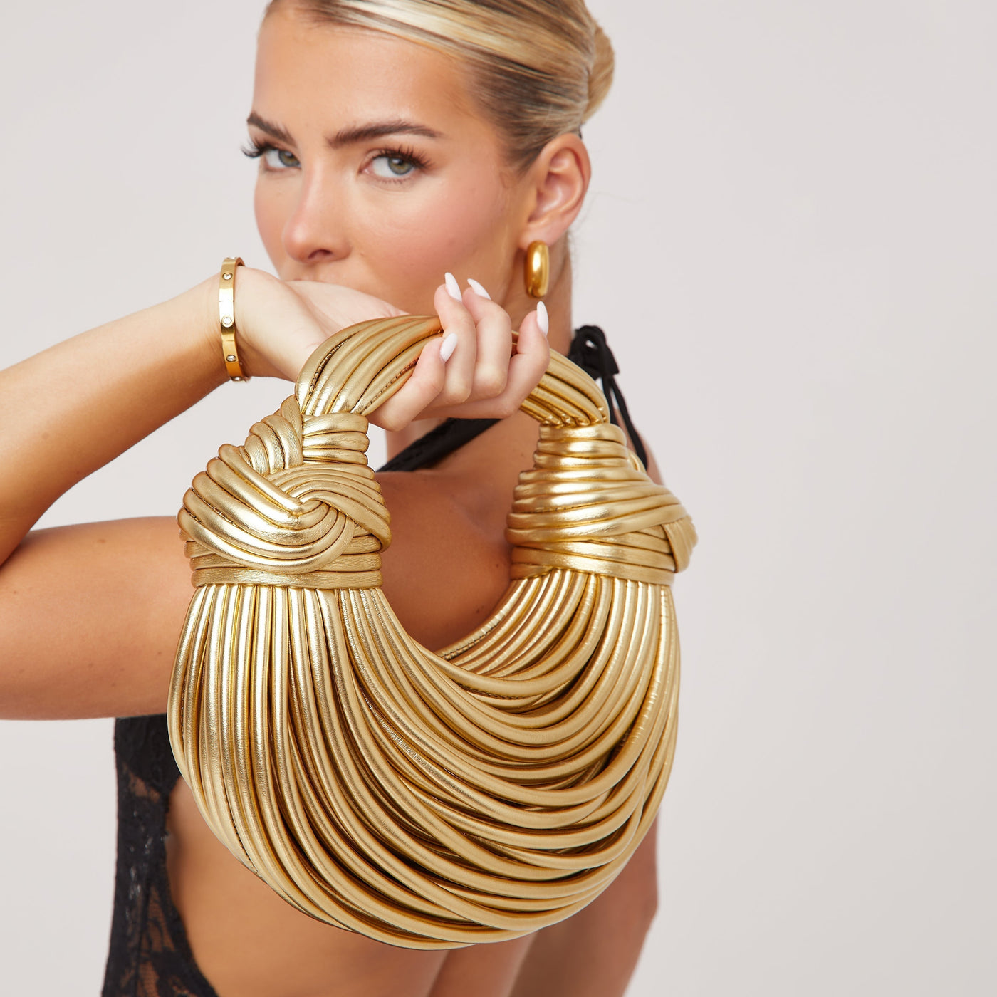 Luxuriöse goldfarbene Tasche mit skulpturalem Griff