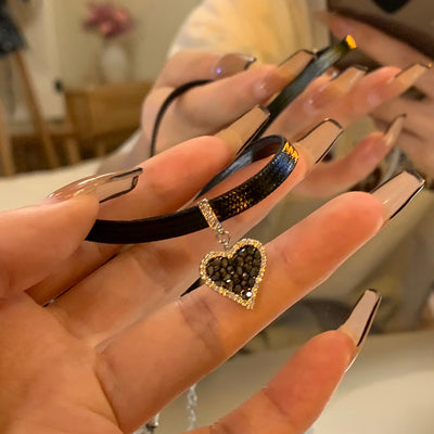 Schwarze Herz-Ohrringe mit funkelnden Diamanten